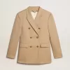 Blazer cu două rânduri de nasturi pentru femei, de culoare nisipiu, cu nasturi heraldici aurii Blazer cu două rânduri de nasturi pentru femei, de culoare nisipiu, cu nasturi heraldici aurii