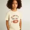 Tricou pentru băieți, de culoare albă uzată, cu inscripții multicolore