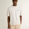 Tricou unisex alb cu imprimeu mediteranean și patch Pescheria Golden pe mânecă Tricou unisex alb cu imprimeu mediteranean și patch Pescheria Golden pe mânecă