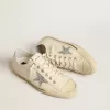 V-Star din pânză bej cu o stea argintie strălucitoare V-Star din pânză bej cu o stea argintie strălucitoare